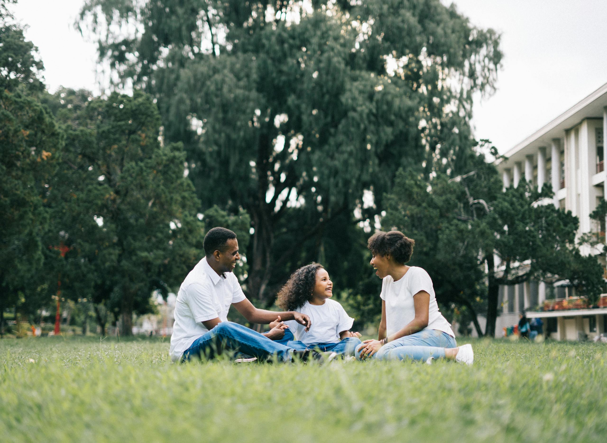 A happy family enjoying quality time together outdoors in a lush green park.